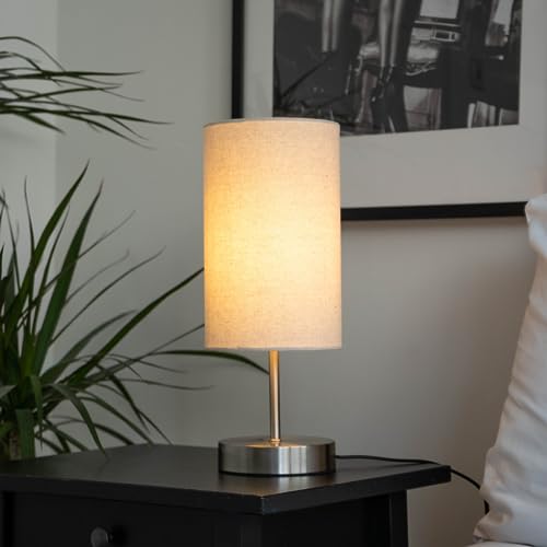 Caza lamp glowing warmly on a black bedside table