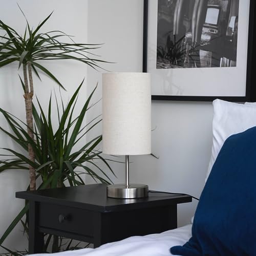 Caza lamp beside a bed with navy pillow
