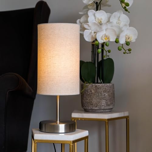 Caza lamp on a marble side table next to orchids